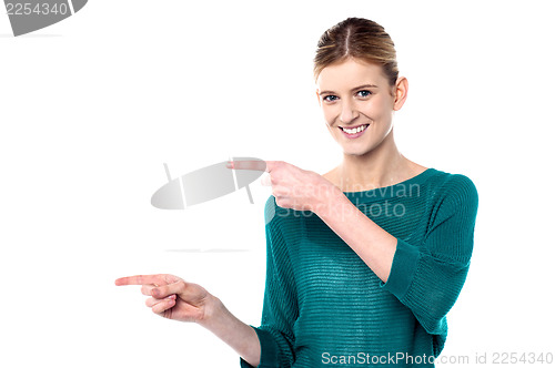 Image of Attractive girl pointing towards copy space area