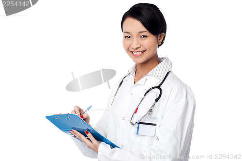 Image of Pretty female doctor writing prescription