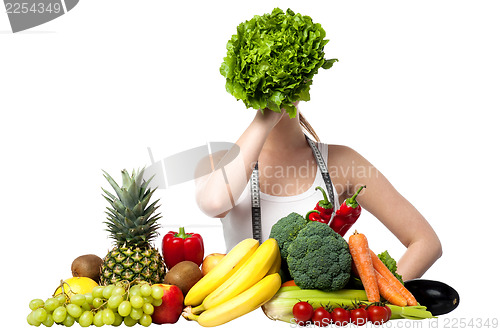 Image of Beautiful woman hiding her face with spinach