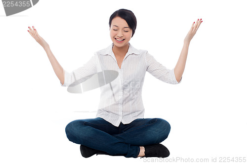 Image of Pretty girl practicing meditation smilingly