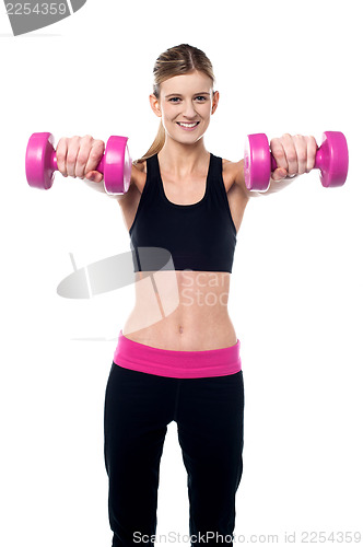 Image of Trainer holding dumbbells in her outstretched arms