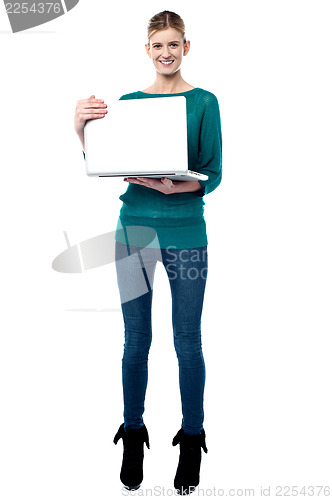 Image of Full length shot of smiling girl holding laptop