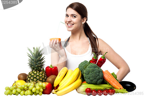 Image of Pretty girl sipping orange juice with a straw