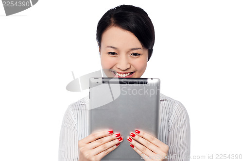 Image of Shy pretty corporate lady holding tablet device