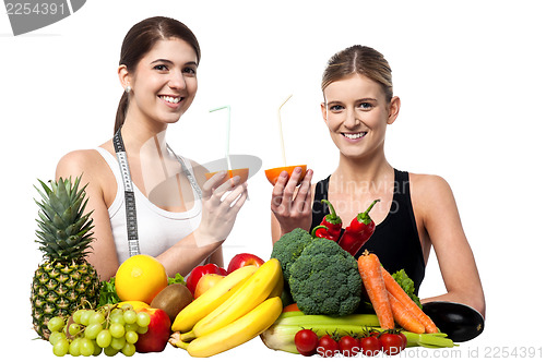 Image of Smiling girls holding juicy slice of an orange