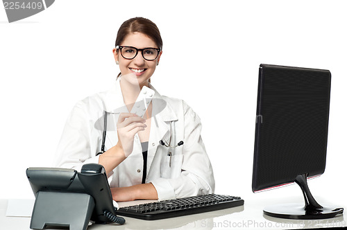 Image of Smiling lady doctor holding pack of medicine