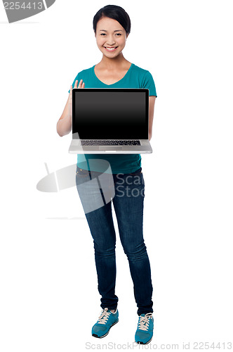 Image of Salesgirl presenting brand new laptop for sale
