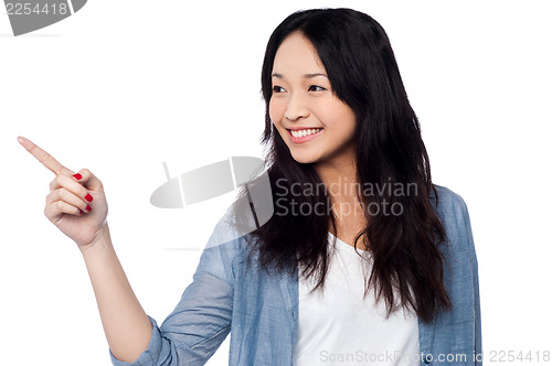 Image of Young chinese girl pointing and looking outside