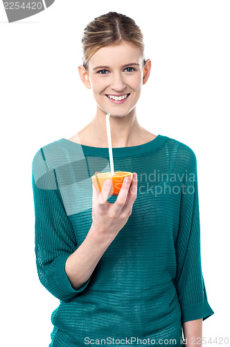 Image of Girl sipping orange juice through straw