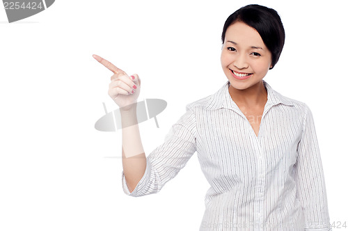 Image of Happy young girl pointing at copy space area