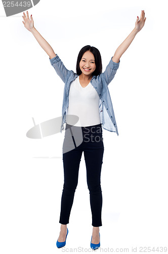 Image of Joyous female raising arms in excitement