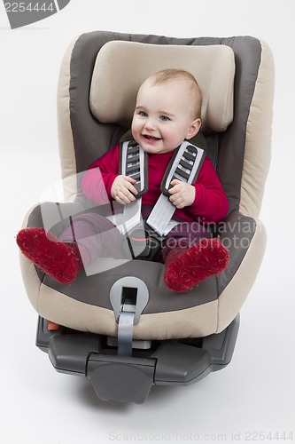 Image of toddler in booster seat for a car in light background