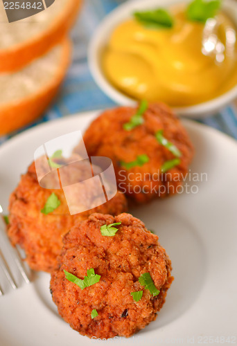 Image of meat balls with mustard on white dish
