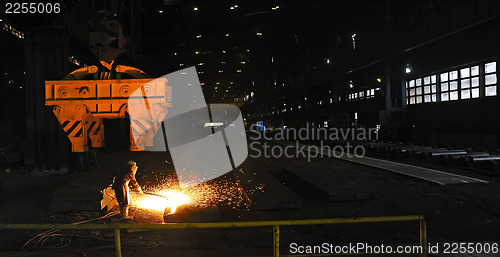 Image of worker using torch cutter to cut through metal