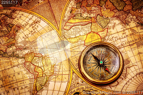 Image of Vintage compass lies on an ancient world map.