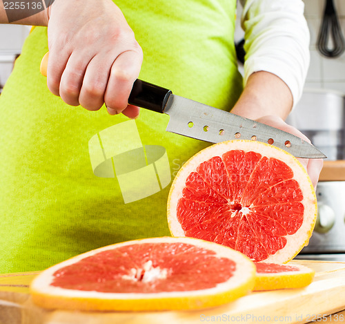Image of Woman's hands cutting grapefruit