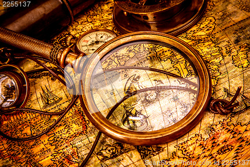 Image of Vintage magnifying glass lies on an ancient world map