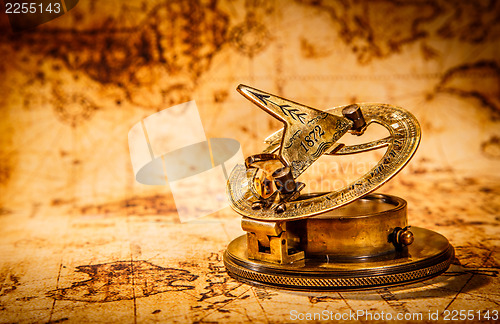 Image of Vintage compass lies on an ancient world map.