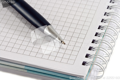 Image of Blue pen with notebook closeup