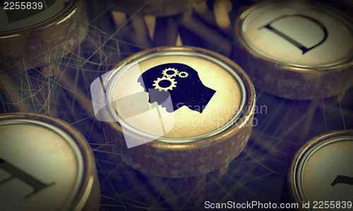 Image of Head With Gears on Grunge Typewriter Key.