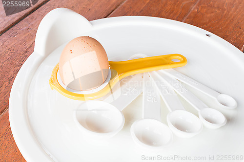 Image of Bakery preparing with egg, yolk separator and spoon 