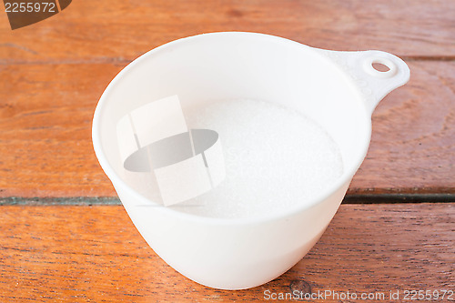 Image of Bakery white sugar measured in plastic  cup 