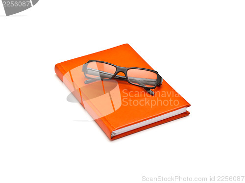 Image of Orange book and glasses, isolated on white background