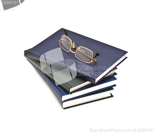 Image of Stack of books and glasses, isolated on white background