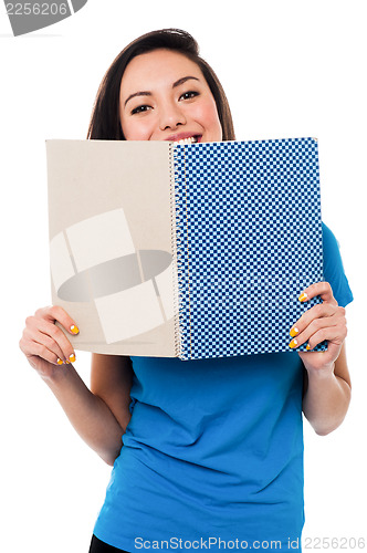 Image of Young girl hiding her face with notebook