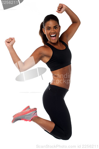 Image of Woman in sportswear jumping with joy