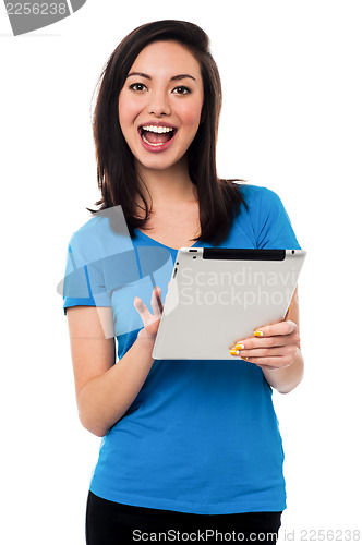 Image of Attractive asian girl browsing on tablet device