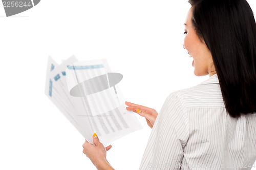 Image of Cheerful female manager holding business reports