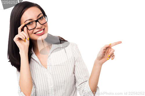 Image of Woman adjusting her spectacles and pointing away