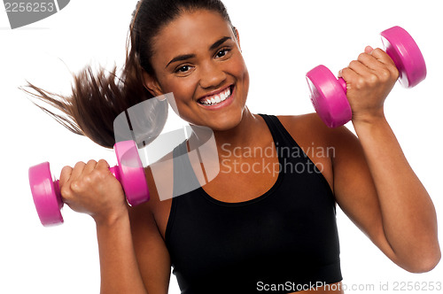 Image of Happy fitness woman lifting dumbbells