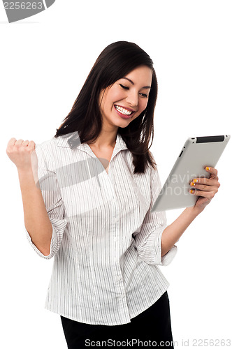 Image of Excited businesswoman holding touch pad