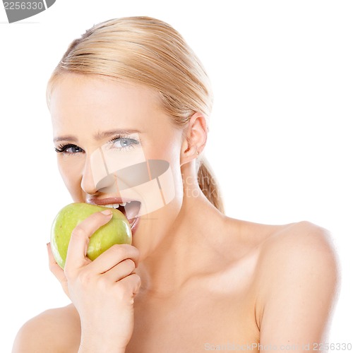 Image of Side view of blond woman she bites an apple