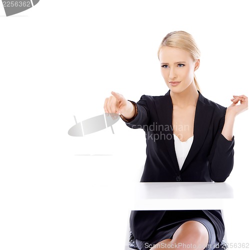 Image of Sexy blond business woman sitting in front of desk