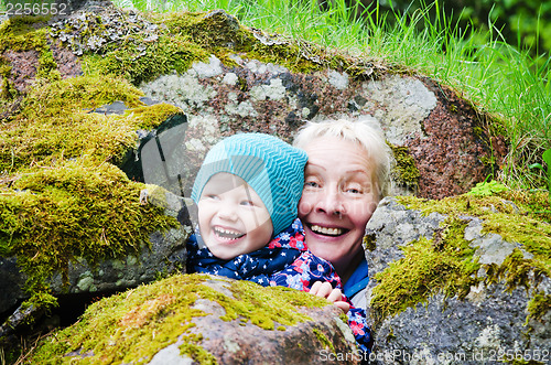 Image of Grandmother with granddaughter hide among stones 