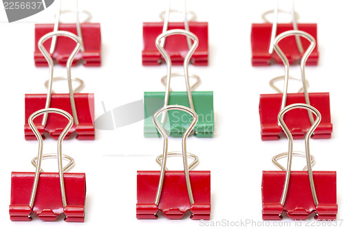 Image of Green paper clip among red