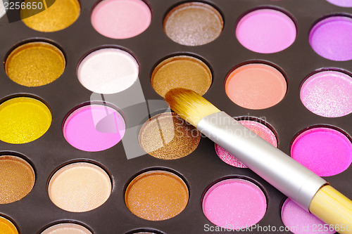 Image of Set of multicolored eyeshadows with makeup brush