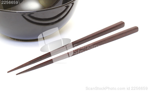 Image of Dark wooden chopsticks and ceramic bowl