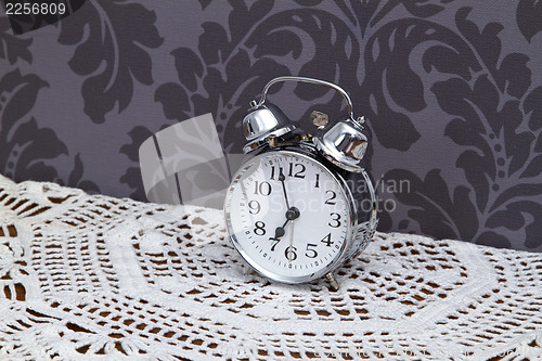 Image of Antique alarm clock on table cloth 