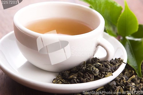 Image of cup of green tea with freh leaves