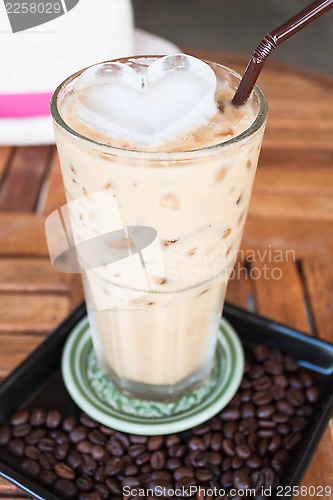 Image of Cold glass coffee with milk and heart ice cube  