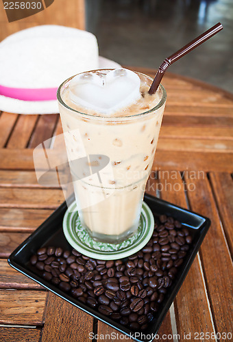 Image of Cold glass of milk espresso and heart ice cube  