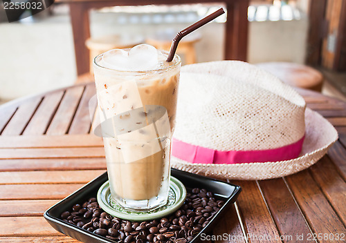 Image of Cold glass of iced milk coffee with ice cube  