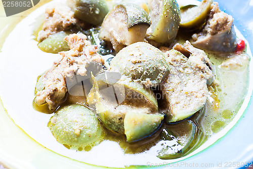 Image of A bowl of spicy green curry with chicken and eggplant