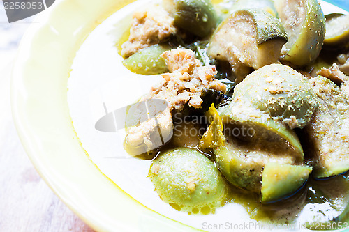 Image of A bowl of spicy green curry with chicken and eggplant
