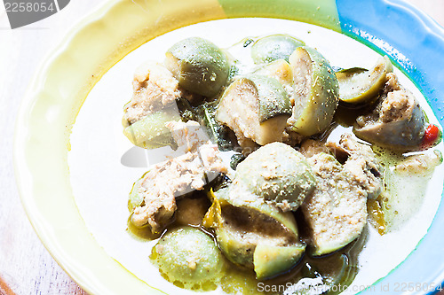 Image of A bowl of spicy green curry with chicken and eggplant