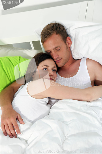 Image of Young couple relaxing together in bed